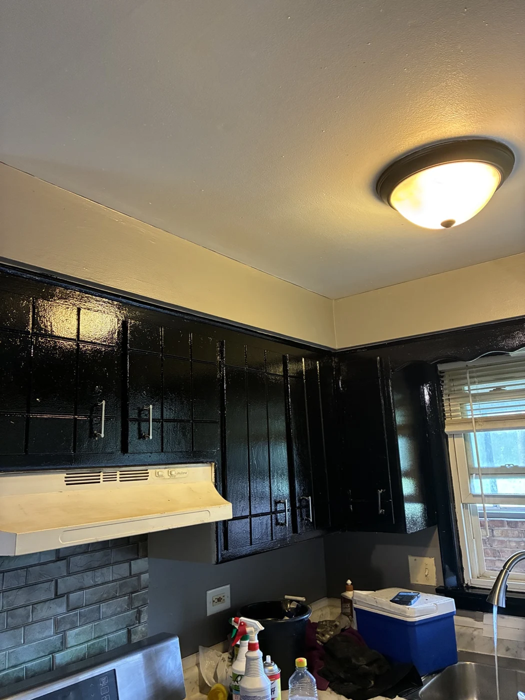Kitchen cabinetry with a dark finish beneath light upper walls.